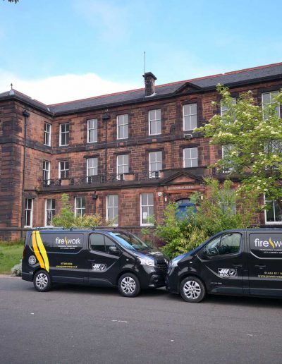 two chimney sweeping vans from fire work chimney sweeps are parked outside of Jordanhill college in Glasgow