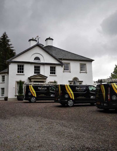 three chimney sweeping vans are parked outside of a scottish property